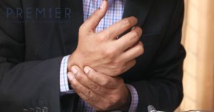 Man with Suit and Button Down Shirt Holding His Wrist